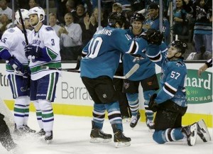 San Jose Sharks' Tommy Wingels (57) celebrates with teammates after scoring against the Vancouver Canucks during the third period of an NHL hockey game on Thursday, Oct. 3, 2013, in San Jose, Calif. (AP Photo/Marcio Jose Sanchez)