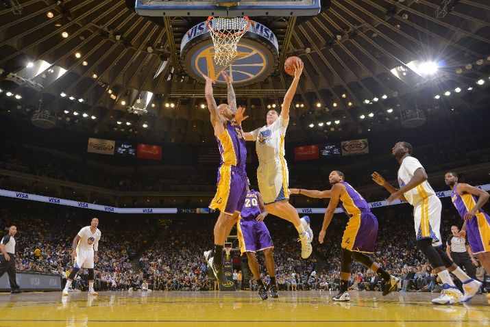 OAKLAND, CA - DECEMBER 21: Klay Thompson #11 of the Golden State Warriors shoots a layup against Robert Sacre #50 of the Los Angeles Lakers on December 21, 2013 at Oracle Arena in Oakland, California. NOTE TO USER: User expressly acknowledges and agrees that, by downloading and or using this photograph, user is consenting to the terms and conditions of Getty Images License Agreement. Mandatory Copyright Notice: Copyright 2013 NBAE (Photo by Rocky Widner/NBAE via Getty Images)