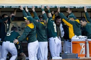 OAKLAND, CA - MAY 09: John Jaso #5 of the Oakland Athletics is congratulated by teammates in the dugout after hitting a home run against the Washington Nationals during the third inning at O.co Coliseum on May 9, 2014 in Oakland, California. (Photo by Jason O. Watson/Getty Images)