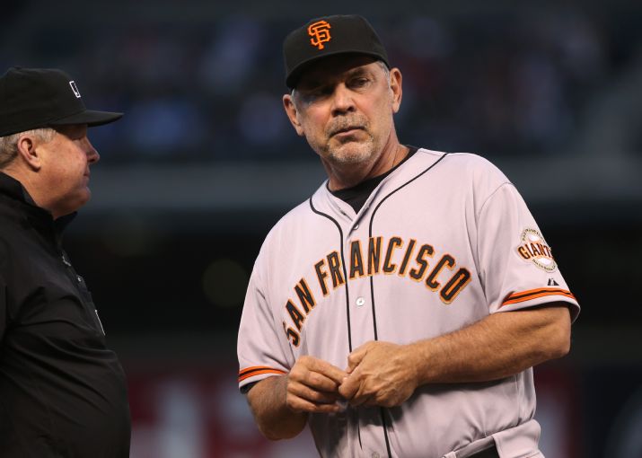 San Francisco Giants manager Bruce Bochy, right, asks third base umpire Bill Miller for an replay to check ruling on hit by Tyler Colvin against the Colorado Rockies in the fifth inning of a baseball game in Denver on Tuesday, May 20, 2014. Colvin was awarded a double after the initial call was reviewed. (AP Photo/David Zalubowski)
