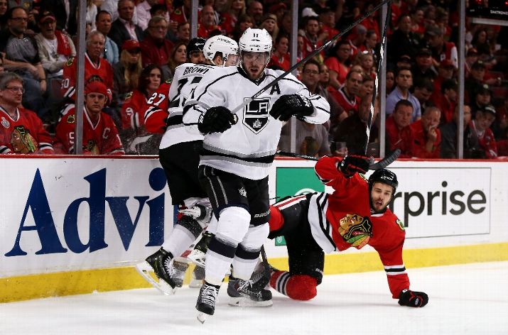 CHICAGO, IL - MAY 21: Dustin Brown #23 of the Los Angeles Kings checks Johnny Oduya #27 of the Chicago Blackhawks as Anze Kopitar #11 of the Los Angeles Kings looks on in the first period of Game Two of the Western Conference Final during the 2014 Stanley Cup Playoffs at United Center on May 21, 2014 in Chicago, Illinois. (Photo by Jonathan Daniel/Getty Images)