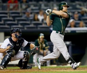 NEW YORK, NY - JUNE 03: Brandon Moss #37 of the Oakland Athletics hits a solo home run in the 10th inning as Brian McCann #34 of the New York Yankees defends on June 3, 2014 at Yankee Stadium in the Bronx borough of New York City. (Photo by Elsa/Getty Images)