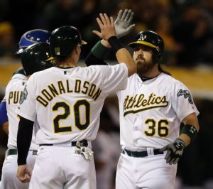 Oakland Athletics' Josh Donaldson, left, congratulates Derek Norris, right, after Norris hit a three-run home run off off Texas Rangers' Shawn Tolleson in the sixth inning of a baseball game Tuesday, June 17, 2014, in Oakland, Calif. (AP Photo/Ben Margot)