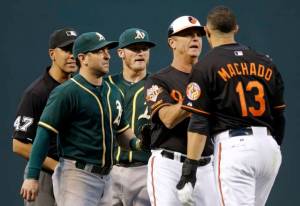 Baltimore Orioles third base coach Bobby Dickerson, second from right, backs Manny Machado (13) away from Oakland Athletics second baseman Nick Punto, second from left, and third baseman Josh Donaldson after Donaldson tagged him out in the third inning of a baseball game, Friday, June 6, 2014, in Baltimore. Also pictured is umpire Gabe Morales, left. (AP Photo/Patrick Semansky)