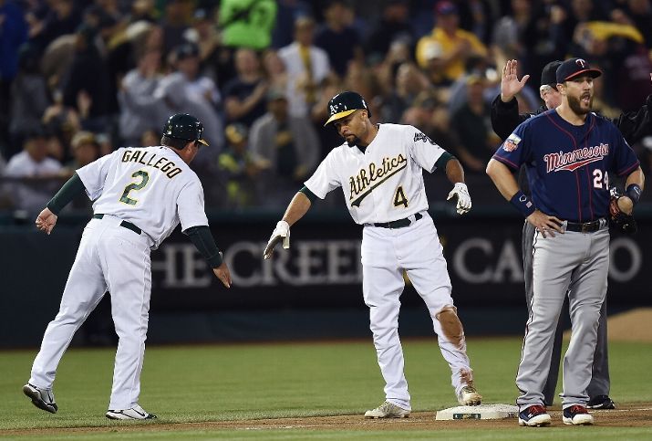 OAKLAND, CA - AUGUST 08: Coco Crisp #4 of the Oakland Athletics is congratulated by third base coach Mike Gallego #2 after Crisp his a three-run triple with the bases loaded against the Minnesota Twins in the bottom of the fifth inning at O.co Coliseum on August 8, 2014 in Oakland, California. (Photo by Thearon W. Henderson/Getty Images)