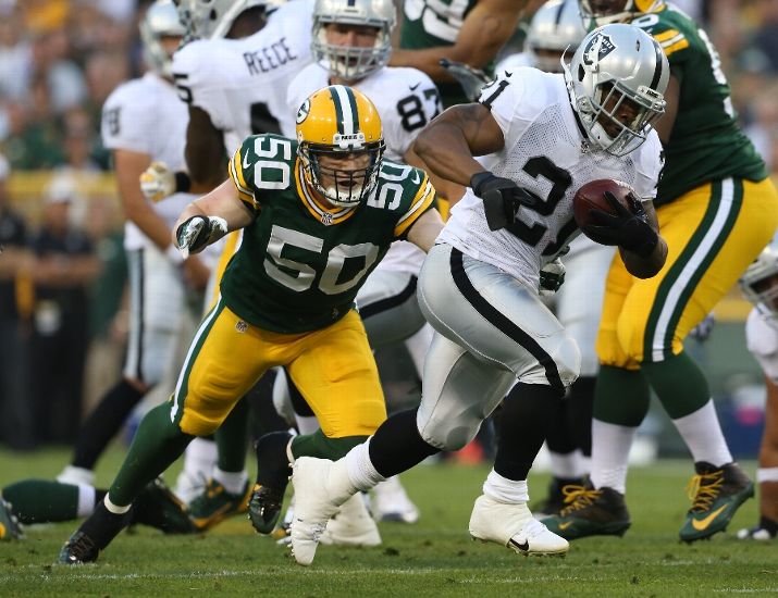GREEN BAY, WI - AUGUST 22: Maurice Jones Drew #21 of the Oakland Raiders runs past AJ Hawk #50 of the Green Bay Packers for a first quarter touchdown run during a preseason game at Lambeau Field on August 22, 2014 in Green Bay, Wisconsin. (Photo by John Konstantaras/Getty Images)