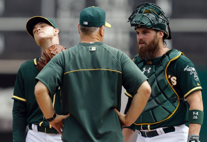 Oakland Athletics' Sonny Gray, left, is visited by pitching coach Curt Young, center, and catcher Derek Norris in the first inning of a baseball game against the Texas Rangers Thursday, Sept. 18, 2014, in Oakland, Calif. (AP Photo/Ben Margot)