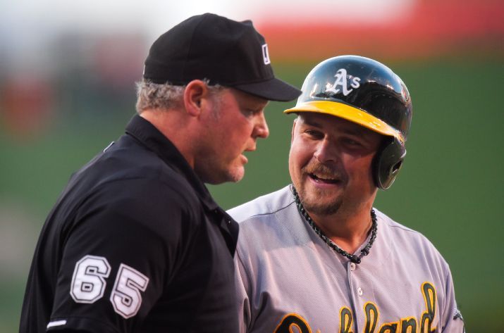 Oakland Athletics' Billy Butler, right, talks to home plate umpire Ted Barrett after striking out during the first inning of a baseball game against the Los Angeles Angels, Friday, June 12, 2015, in Anaheim, Calif. (AP Photo/Mark J. Terrill)