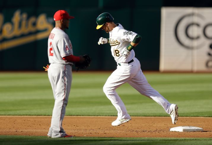 Oakland Athletics' Ben Zobrist, right, runs past Los Angeles Angels shortstop Erick Aybar (2) after Zobrist hit a three run home run off Angels' Matt Shoemaker in the first inning of a baseball game Friday, June 19, 2015, in Oakland, Calif. (AP Photo/Ben Margot)